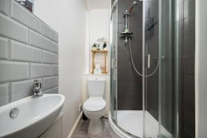 a bathroom with a shower and a toilet and a sink at Strand Central Apartments 4th Floor in London +18 photos