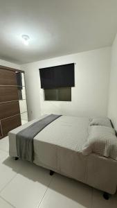 a bedroom with a bed and a flat screen tv at Studio 06 in Caruaru +27 photos