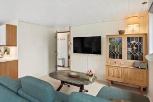 a living room with a blue couch and a table at M225-Idestrup-Jasminvej-22 in Bøtø By
