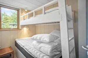 a bedroom with a bunk bed with white pillows at M225-Idestrup-Jasminvej-22 in Bøtø By