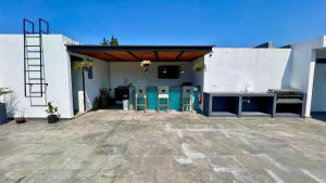 eine Terrasse mit einer Küche mit Hockern und einer Spüle in der Unterkunft Suites Heriberto Frías in Mexiko-Stadt