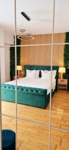a bedroom with a green bed with a cat on it at Penthouse View Aeroport Iasi in Iaşi