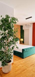 a bedroom with a bed and a potted plant at Penthouse View Aeroport Iasi in Iaşi