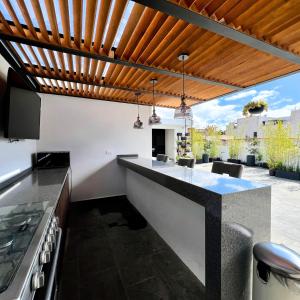 eine Außenküche mit einer hölzernen Pergola in der Unterkunft Suites Heriberto Frías in Mexiko-Stadt