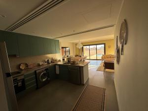 a kitchen with green cabinets and a washing machine at Gouna Ancient Hill 3 BDR Nanny Privat Pool Lagoon View in El Gouna