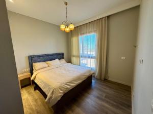 a bedroom with a bed and a large window at Gouna Ancient Hill 3 BDR Nanny Privat Pool Lagoon View in El Gouna +17 photos