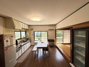 a kitchen with a table and a dining room at Atami Umine Villa in Atami