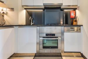 a kitchen with stainless steel appliances and white cabinets at Seaview & Marina View Studio in Dubai