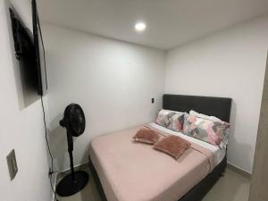 a small bedroom with a bed with a fan at Apartamento Familiar y Tranquilo in Sabaneta