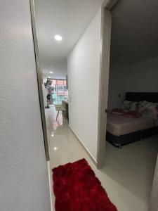 a bedroom with a bed and a red rug at Apartamento Familiar y Tranquilo in Sabaneta
