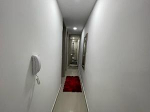 a hallway with a phone and a red rug at Apartamento Familiar y Tranquilo in Sabaneta
