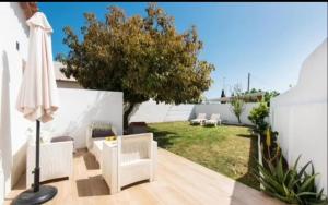 a patio with two chairs and an umbrella at La Cabaña Sol y Playa in Churriana