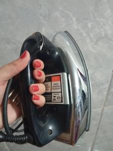 a person holding a hair dryer in their hand at Residencial Lima - Quarto 04 in São Luís +11 photos