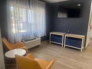 a living room with a tv and a table and chairs at Spark by Hilton Lakewood Denver Southwest in Lakewood