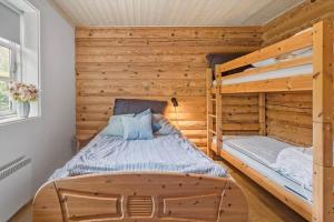 a bedroom with two bunk beds in a log cabin at M319-Vaeggerlose-Marielyst-Strandpark-124 in Marielyst