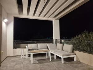 a patio with a couch and tables and a large window at Alma suite in Ashdot Ya‘aqov