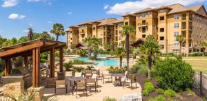 an exterior view of a resort with tables and chairs at Lakefront Horseshoe Bay Resort Shared Pool Dock in Horseshoe Bay