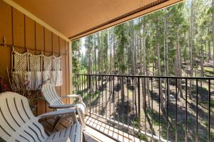 a screened porch with two chairs and a view of the woods at Beaver Village Unit #0131 in Winter Park