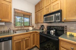 a kitchen with wooden cabinets and a black stove top oven at Beaver Village Unit #0131 in Winter Park