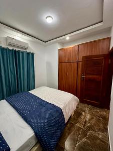 ein Schlafzimmer mit einem Bett und einem Holzschrank in der Unterkunft Résidence EDEN in Abidjan + 20 Fotos