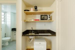 a kitchen with a sink and a microwave at Estúdios no Centro Histórico de Poa - ELSs in Porto Alegre +24 photos