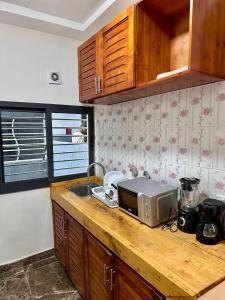 eine Küche mit einer Arbeitsfläche, auf der eine Mikrowelle steht in der Unterkunft Résidence EDEN in Abidjan