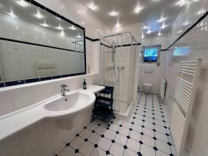 a white bathroom with a sink and a shower at 3 Zimmer Wohnung in Reetdachanwesen Hus op de Duen in Sankt Peter-Ording +21 photos