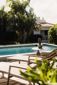 una piscina con sedie e un tavolo accanto a una casa di Casa Kolo Kolo a Willemstad