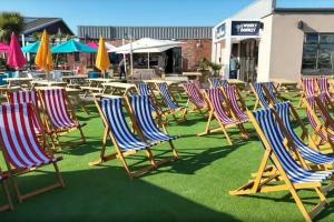 a group of lawn chairs and tables and umbrellas at The Retreat in Skipsea