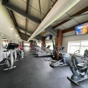 a gym with a row of treadms and cardio machines at The Retreat in Skipsea