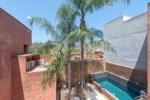 einen externen Blick auf ein Haus mit einem Pool und Palmen in der Unterkunft Casa Murallas para 6 con piscina en Alcudia cerca de playas in Alcúdia
