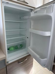 an empty refrigerator with its door open in a kitchen at Große 2 Ferienwohnung Gästehaus NEUBAU Merzig 100 m2 in Merzig