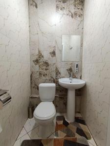 un baño con inodoro y lavabo en Хостел Nino, en Tashkent