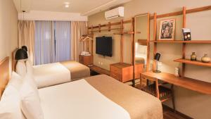 a hotel room with a bed and a desk at AQ Tailored Suites in Buenos Aires +62 photos