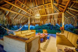 パロミノにあるTröpical house with amazing view by KeyPöint!のわらぶき屋根のソファと椅子のあるリビングルーム