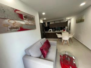 Una sala de estar con un sofá blanco y una mesa. en Apartamento Ideal y Tranquilo, en Sabaneta