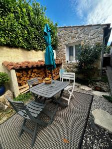 a table and chairs and an umbrella on a patio at Le jardin secret in Uchaud
