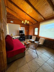 a bedroom with a red bed and a living room at Wau Purul in Cholila +18 photos