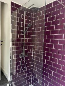 a purple tiled shower with a shower head in a bathroom at 3 Double Bedroom Home-Sleeps 8 - Castle Donnington in Castle Donington