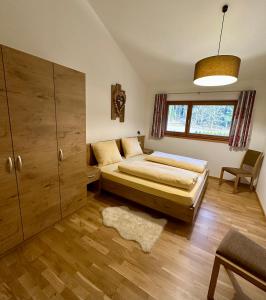 FiumesにあるFrunhaus - Zimmer mit Frühstück, Apartments, Ferienwohnungenのベッドルーム1室(ベッド1台付)、キャビネットが備わります。