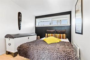 a bedroom with a bed with a yellow pillow on it at M167-Vaeggerlose-Savavej-31 in Marielyst