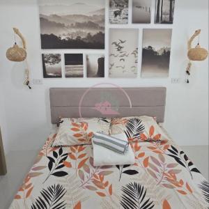 碧瑶Stanford 6F19 Baguio Condo by Dei Gratia的卧室内的一张床铺,墙上挂着照片