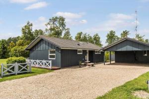a black barn with a white fence and a yard at M323-Vaeggerlose-Skovlystvej-38 in Bøtø By