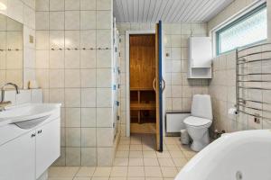 a bathroom with a toilet and a sink and a tub at M323-Vaeggerlose-Skovlystvej-38 in Bøtø By +13 photos