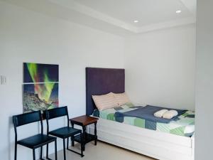 a bedroom with a bed and two chairs and a table at Baguio Staycation in Baguio