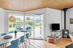 a dining room with a table and chairs and a television at M323-Vaeggerlose-Skovlystvej-38 in Bøtø By