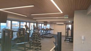 a gym with rows of treadmills and elliptical machines at Aconchegante apartamento studio na Barra in Salvador