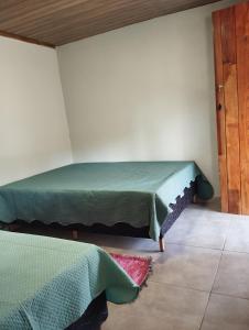 una stanza con un letto nell'angolo di una stanza di Cottage Blue palm tree nook a Itapecerica