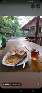 TimbanglawangBatu Katak - Zoey's Homestay的一张桌子,上面放着一盘比萨饼和一杯玻璃