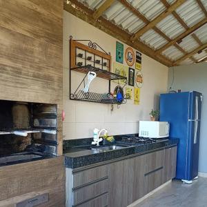 una cucina con frigorifero blu e bancone di Cottage Blue palm tree nook a Itapecerica Altre 59 foto